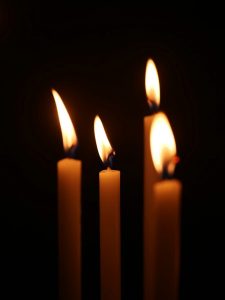 A group of lit candles in a dark room